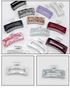 Detailed macro view of assorted large acrylic hair claws in multiple colors and patterns