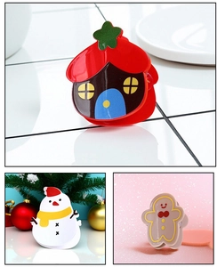 Detailed views of Christmas hair clips featuring snowman, gingerbread man, and mushroom house