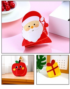 Detail showing Santa Claus, red apple, and gift box designs on acrylic Christmas hair claws