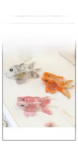 Detailed macro view of fish-shaped acetate hair claws in pearl white, orange and pink