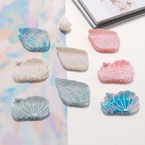 Sparkling resin shell and starfish hair claws in dreamy pastel colors with blue rhinestones
