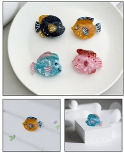 Détail de pinces à cheveux en acétate en forme de poisson avec texture marbrée