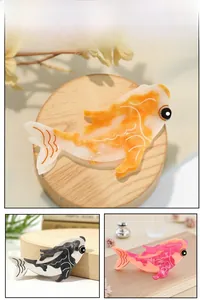 Détail macro des pinces à cheveux en acétate forme carpe koï en orange, noir et rose