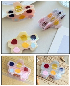 Détail de la pince à cheveux palette avec pois colorés et texture en acétate poli