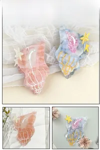 Detail view of shell-shaped acetate hair claws with marble texture and starfish accents