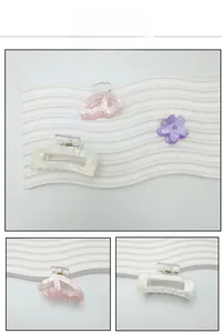 Detail view of acetate floral hair claws and pink butterfly clips with pearlescent finish