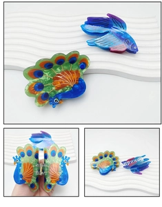 Detailed view of colorful peacock and fish shaped acrylic claw clips with metal spring