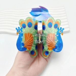 Peacock shaped acrylic hair claw clip with colorful green and blue feather patterns