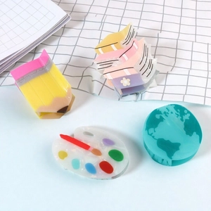 Set mit vier Haarklammern im Schreibwaren-Design wie Stift, Buch, Palette und Erdkugel