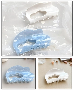 Detailed macro view of large acetate claw clips in marble blue and white colors