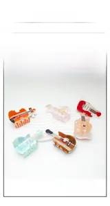 Detailed view of violin and guitar shaped acrylic hair claws with marble texture