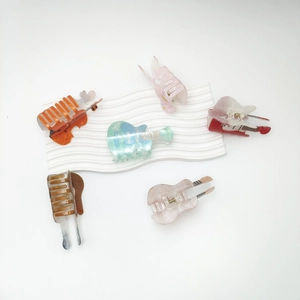 Collection of violin and guitar shaped acrylic hair claws in vibrant assorted colors