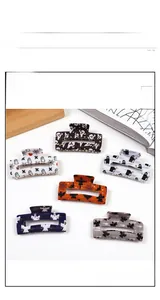 Detail showing a set of Halloween acetate shark hair claws with ghost and spider web prints