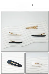 Close-up of black matte and pearl texture acrylic hair clips with gold alloy base