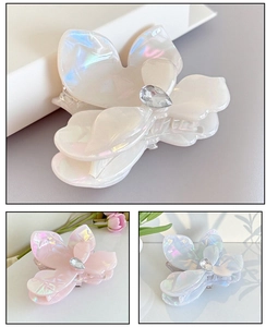 Macro detail of iridescent flower hair claw with pearl finish and teardrop crystal