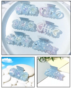 Detail of gradient blue sea shell and dolphin hair claws with pearlescent finish