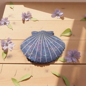 Iridescent deep blue shell hair claw clip with pearl luster on light wooden background