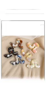 Détails de pinces à cheveux ondulées en acétate avec motifs marbrés et perles de couleurs