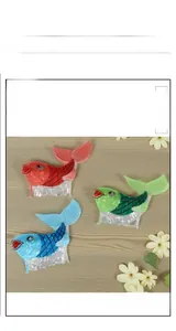 Three fish-shaped hair claws in red, green, and blue with sequined scale textures