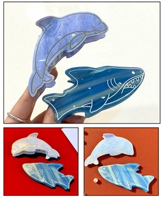 Dettaglio di fermagli per capelli a forma di squalo blu e delfino in acetato