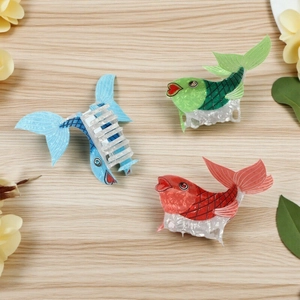 Three creative fish-shaped hair claws in blue, green and red with pearlescent finish