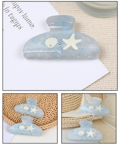 Detail of blue marble claw clip with starfish shell charms and sparkling rhinestones
