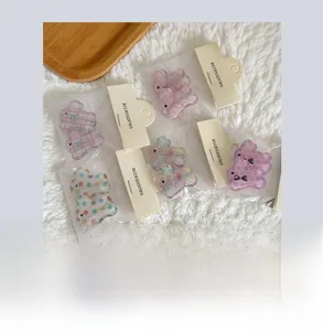 Detail of assorted rabbit hair clips with plaid and star patterns in clear packaging