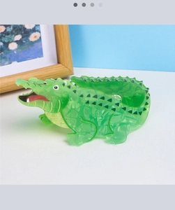 Detail of green translucent crocodile hair claw clip with red tongue and white teeth