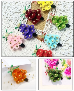 Détail de barrettes sapin de Noël en tricot avec boules en peluche colorées et étoiles dorées