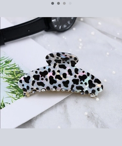 Holographic white hair claw clip with black cow print pattern on lace background
