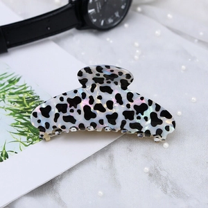Iridescent cow print hair claw clip made of high-quality acetate on lace background