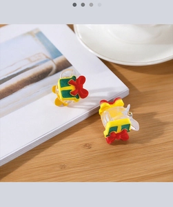 Mini gift box hair claw clip with red bow decoration on a white magazine background