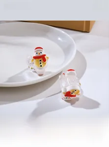 Detail display of a mini Christmas snowman hair claw clip with a festive red hat and scarf