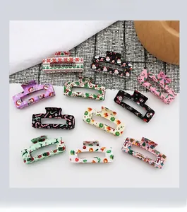 Gros plan de pinces à cheveux rectangulaires aux motifs festifs de Noël et floraux