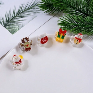 Christmas hair clip set with Santa and reindeer designs in a white ceramic dish