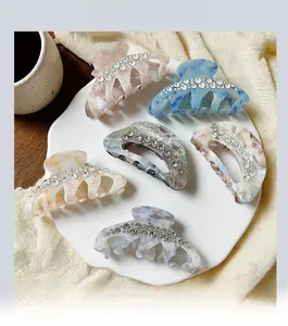 Detail view of five luxury crystal-encrusted pumpkin hair claws in various elegant colors