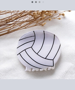 Detailansicht einer Volleyball Haarklammer mit schwarzen Mustern auf weißem Acryl