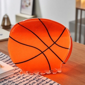 Durchscheinende orangefarbene Basketball-Haarklammer auf einer warmen Holzoberfläche