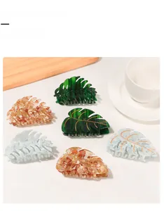 Detailed view of hair claw clips with gold-lined leaf patterns and marbled textures