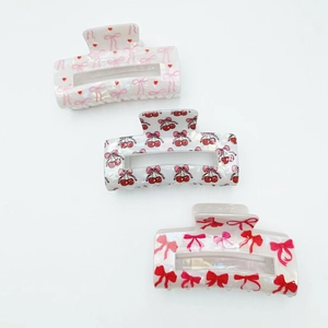 Three rectangular pearlescent hair claws with cherry and bow prints for women