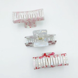 Pearlescent white mermaid hair claw clips with red cherry bow patterns from three angles
