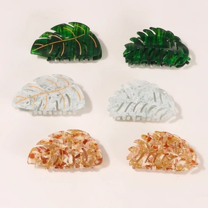 Set of six large monstera leaf hair claws in green, white, and amber with gold leaf veins