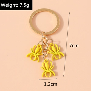 Detail shot of yellow spider keychains with gold ring showing 7.5g weight and 7cm size