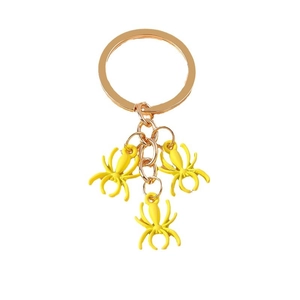 Golden keychain featuring three detailed yellow spider pendants on a rose gold ring link