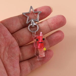 Close-up of creative luminous milk tea keychain with red liquid and star metal buckle
