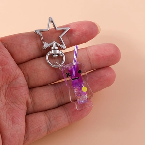 Macro shot of a purple cartoon character keychain with liquid sand and star clasp