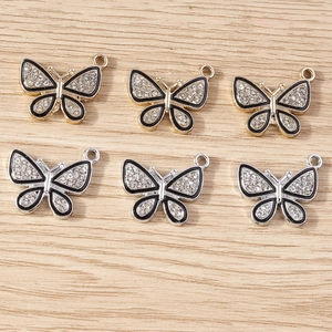 Vue détaillée de pendentifs papillon avec cristaux incrustés et émail noir élégant