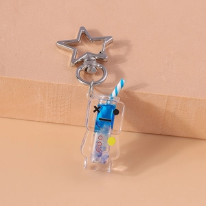 Close-up of creative glowing drink keychain with blue liquid and silver star metal clip
