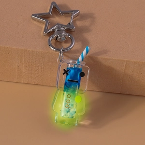 Macro detail of star-shaped clasp and glowing liquid beverage keychain with glitters