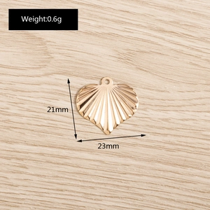 Macro detail of a 21x23mm gold-plated heart pendant featuring a unique radial shell texture